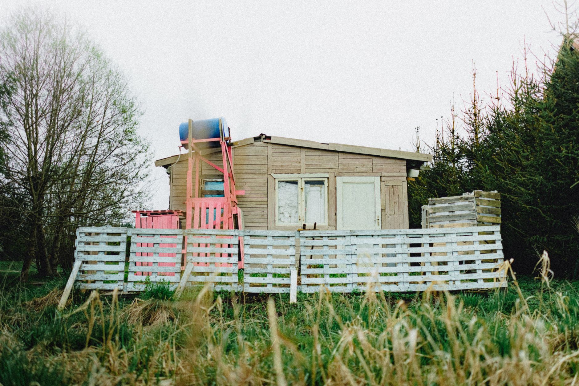 Large outdoor rainwater cistern beside a rural off-grid cabin