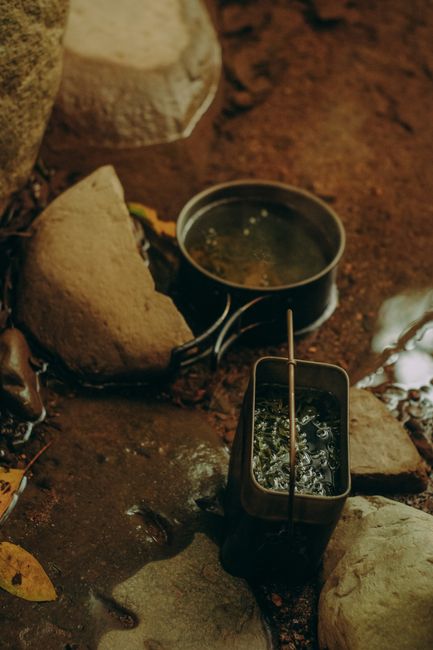 Person using LifeStraw filter to drink from a river