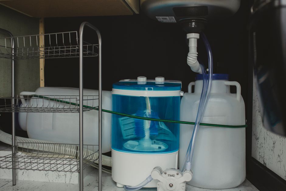 Blue 55-gallon food-grade water storage barrel with siphon pump and bung caps