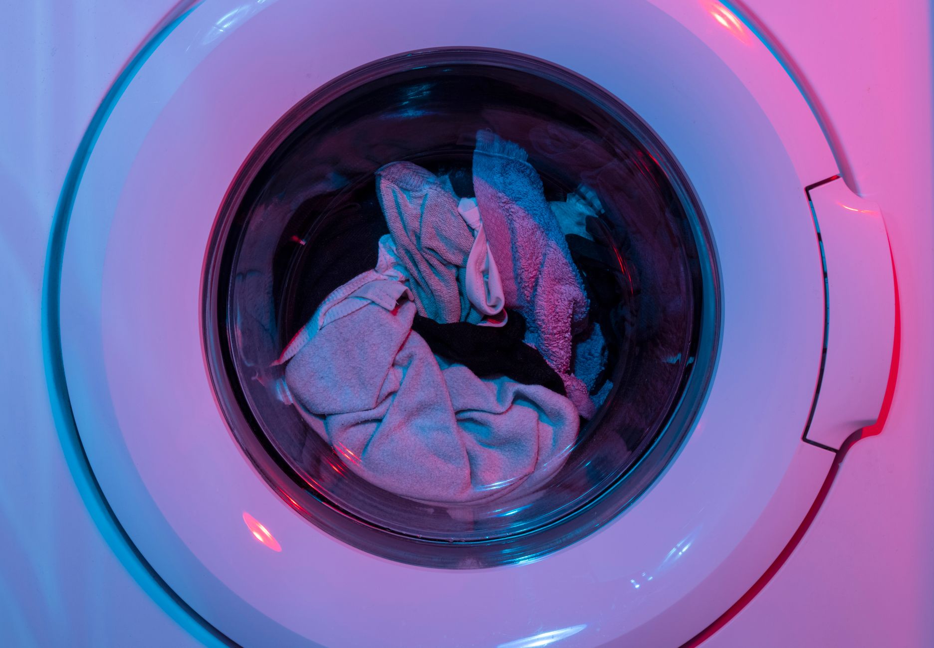 A simple laundry-to-landscape greywater system diverting washing machine water to a garden hose and mulch basin.
