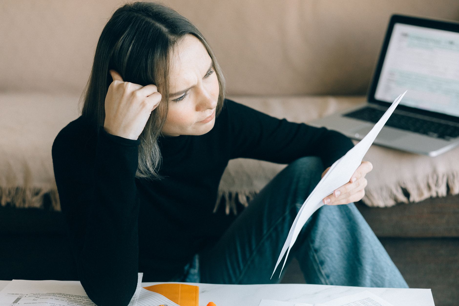 A person holding and examining a printed water quality report at home.