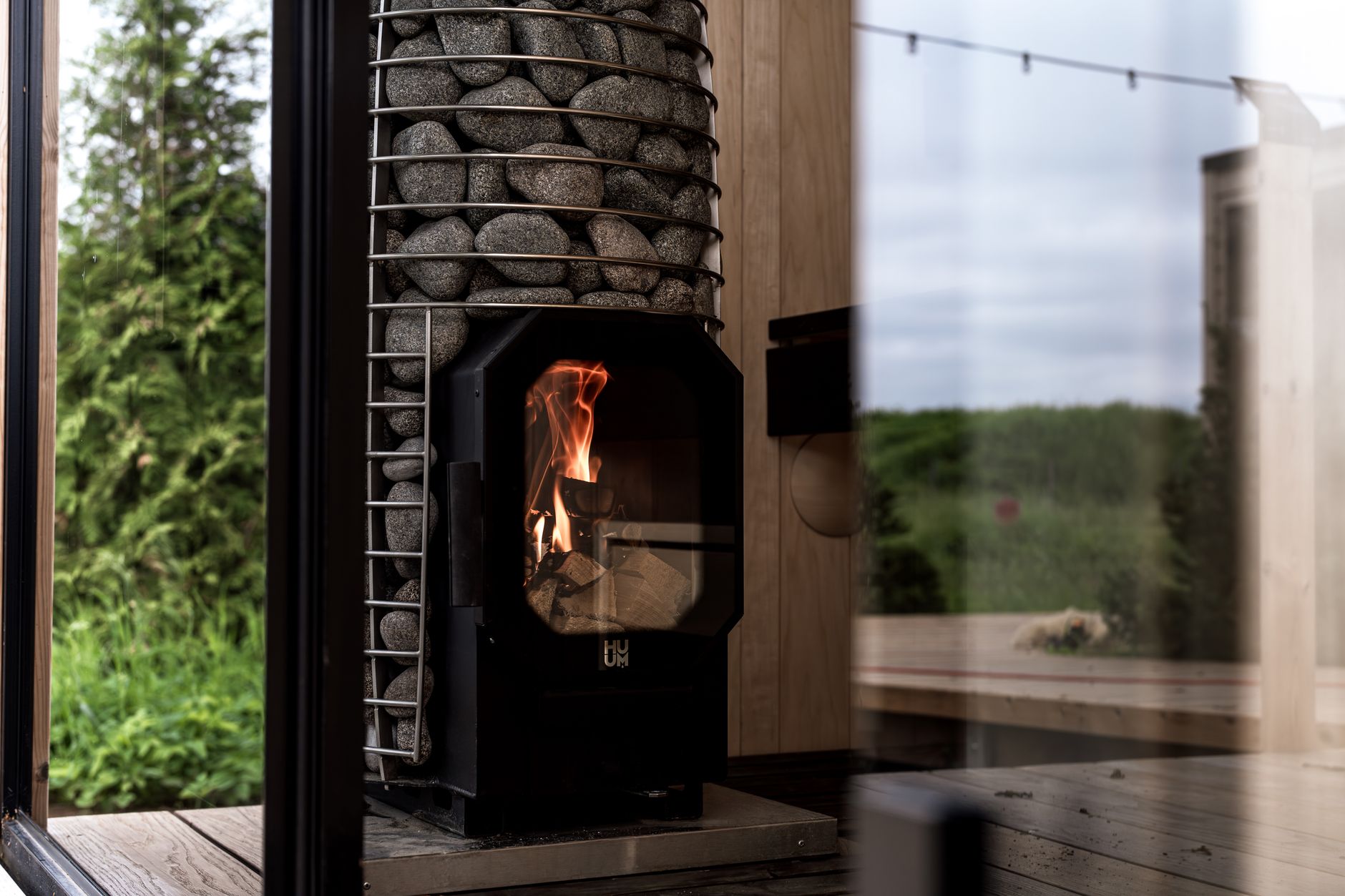 Rustic wood-fired off-grid shower heater with copper coil and firebox