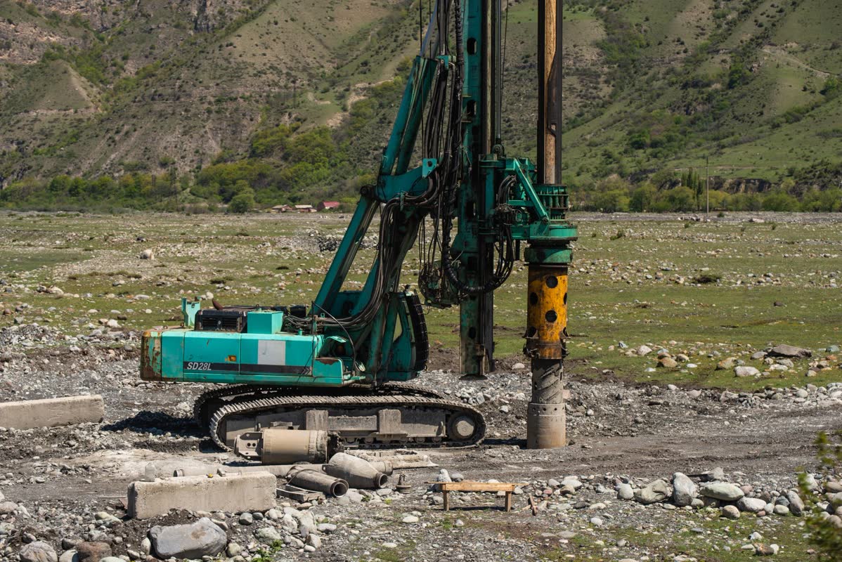 Large rotary drilling rig boring a water well in a rural field
